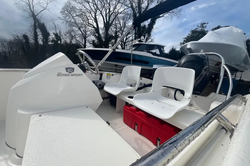 Slide: The Image of 2018 Boston Whaler 170 Super Sport boat interior with seating and motor. - 4