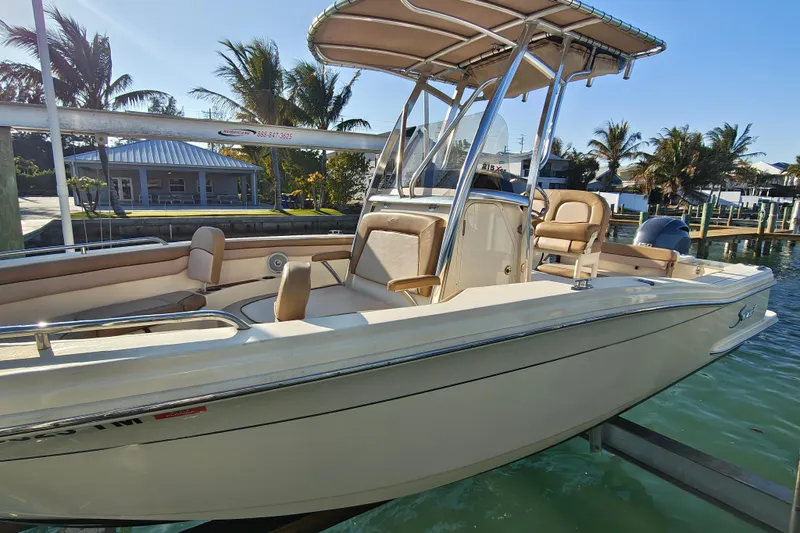Slide: The Image of 2020 Scout 215 XSF boat docked, featuring sleek design and comfortable seating. - 12