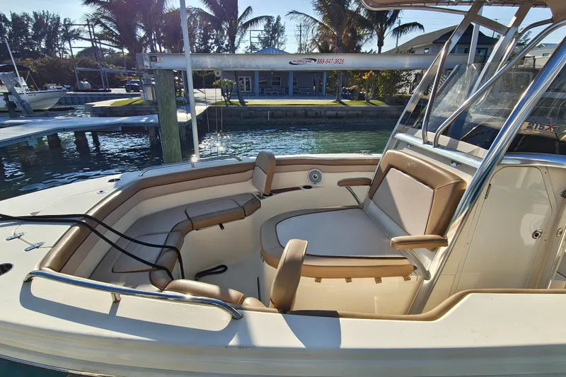 Slide: The Image of 2020 Scout 215 XSF boat interior with tan seating, docked near palm trees. - 13