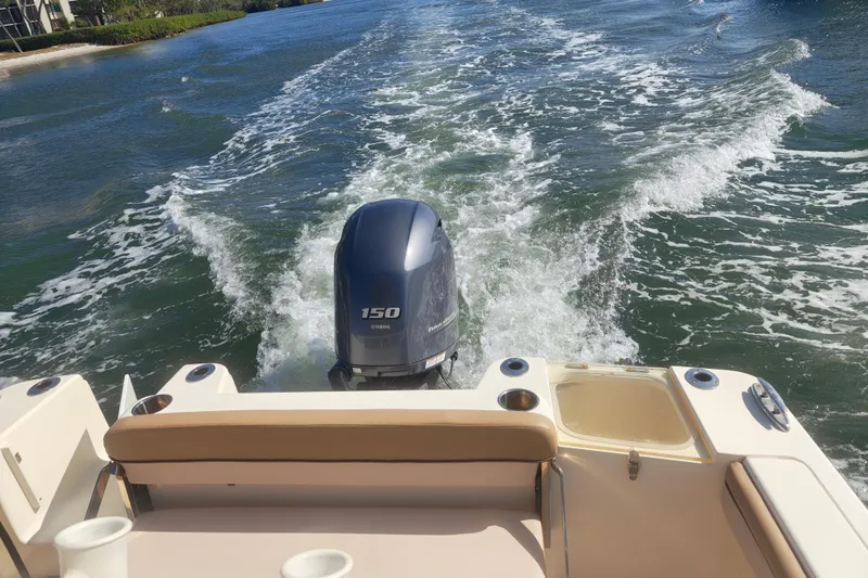 Slide: The Image of 2020 Scout 215 XSF boat with Yamaha 150 engine cruising on water. - 2