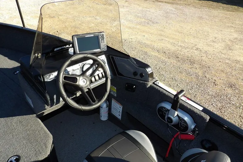 Slide: The Image of 2025 Lund 1775 Adventure SS boat dashboard with steering wheel and navigation system. - 23
