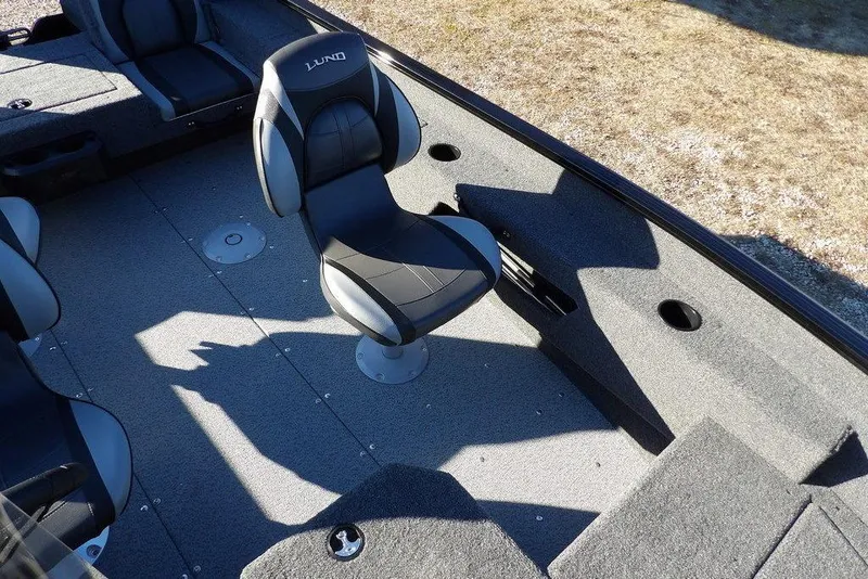 Slide: The Image of 2025 Lund 1775 Adventure SS boat interior with swivel seats and carpeted flooring. - 25