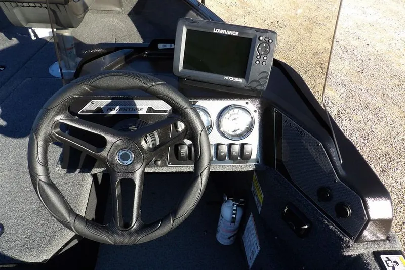 Slide: The Image of 2025 Lund 1775 Adventure SS boat dashboard with steering wheel and Lowrance fishfinder. - 27