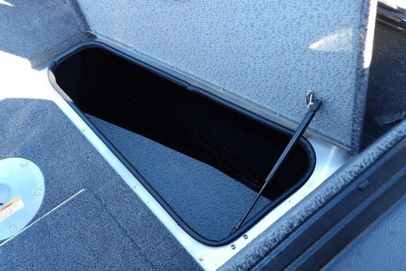 Slide: The Image of Open storage compartment in 2025 Lund 1775 Adventure SS boat, featuring carpeted interior. - 36