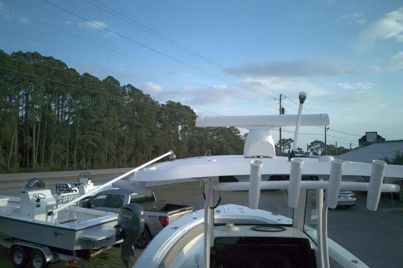 Slide: The Image of 2024 Sea Hunt Gamefish 30 Coffin Box boat with radar and rod holders, parked outdoors. - 8