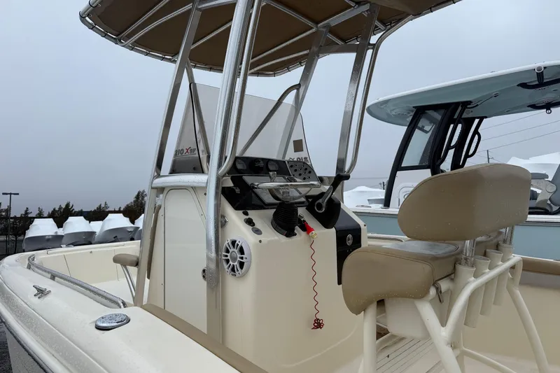 Slide: The Image of 2014 Scout 210 XSF boat with console and seating, overcast sky background. - 2