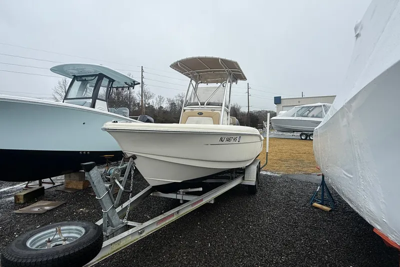 Slide: The Image of 2014 Scout 210 XSF boat on trailer, parked outdoors on a cloudy day. - 3