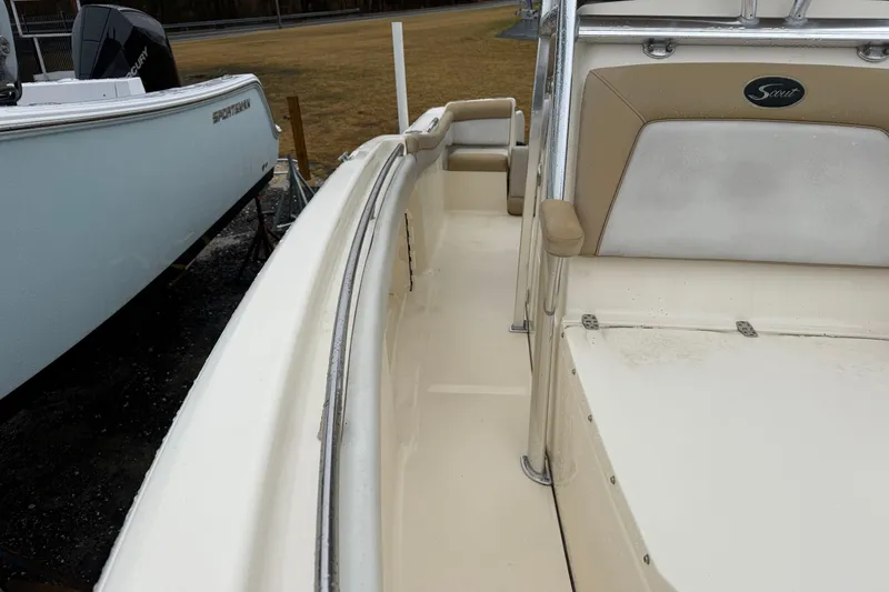 Slide: The Image of 2014 Scout 210 XSF boat interior with beige seating and stainless steel railings. - 7
