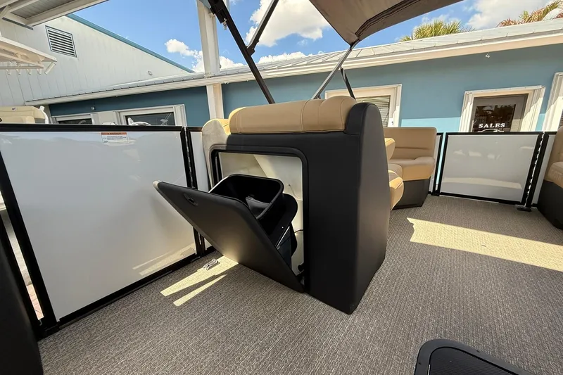 Slide: The Image of Evotti 523QL 2026 boat interior with storage compartment, beige seating, and blue exterior building. - 7