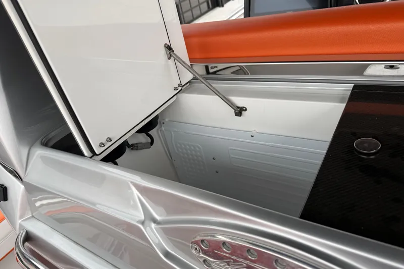 Slide: The Image of 2024 Nor-Tech 500 Sport Center Console storage compartment with open hatch and sleek design. - 24