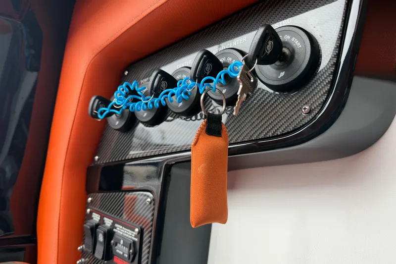 Slide: The Image of 2024 Nor-Tech 500 Sport Center Console dashboard with keys and carbon fiber panel. - 44