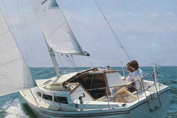 The Image of 1976 Catalina 27 sailboat navigating open waters under clear skies. - 1