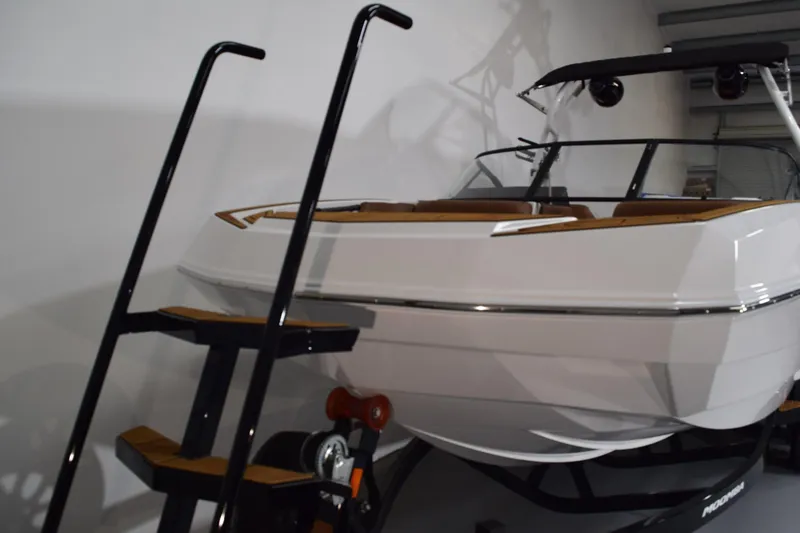 Slide: The Image of 2026 Moomba Tykon boat on trailer with ladder, showcased indoors. - 2