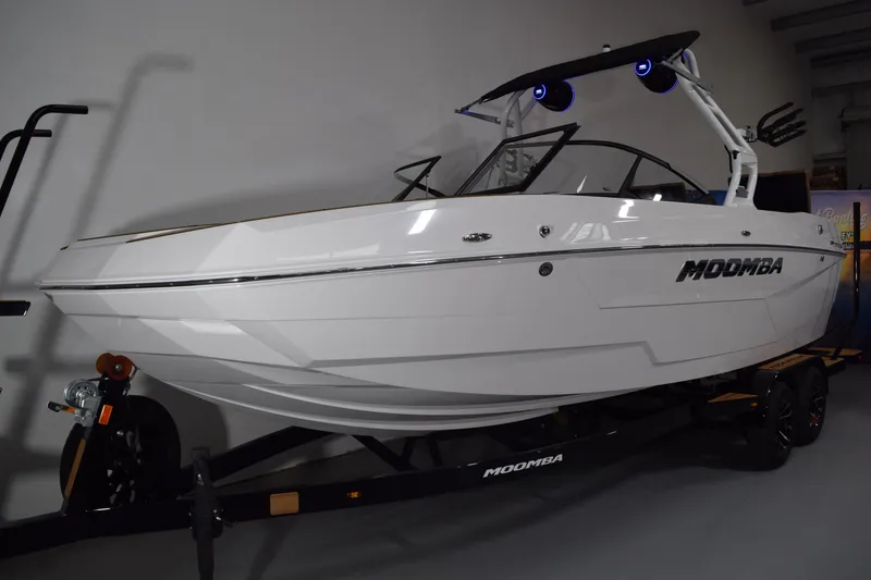 Slide: The Image of 2026 Moomba Tykon boat on trailer, sleek white design, indoor display. - 3