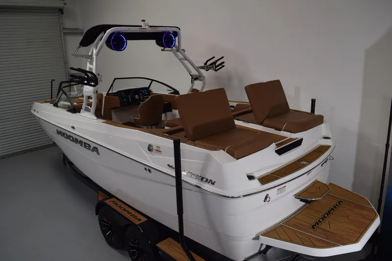 Slide: The Image of 2026 Moomba Tykon boat with brown seating, sleek design, and modern features in a showroom. - 4