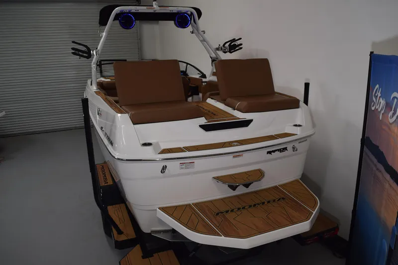 Slide: The Image of 2026 Moomba Tykon boat with brown seating and sleek design in showroom. - 5