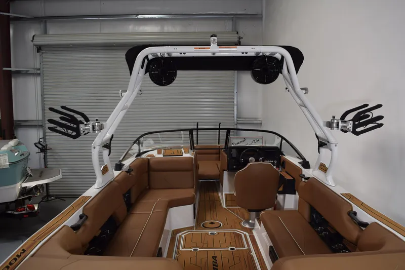 Slide: The Image of 2026 Moomba Tykon boat interior with brown seating and advanced audio system. - 7