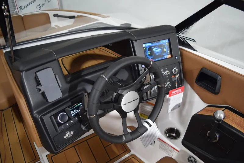 Slide: The Image of 2026 Moomba Tykon boat dashboard with steering wheel, touchscreen display, and control panel. - 9