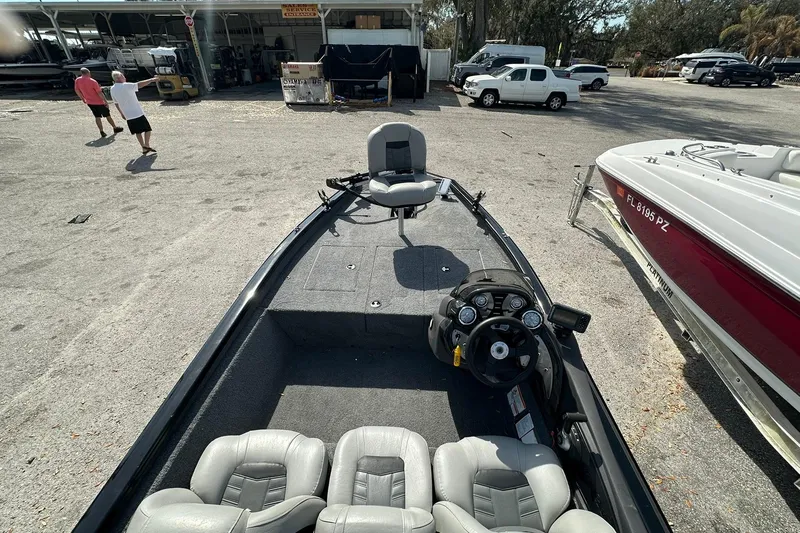 Slide: The Image of 2018 Tracker Pro Team 175 TXW boat interior at a marina, featuring seating and steering console. - 10