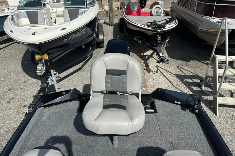 Slide: The Image of 2018 Tracker Pro Team 175 TXW boat with gray seating, parked among other boats. - 17