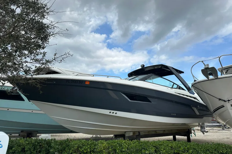 The Image of 2019 Cruisers Yachts 338 Outboard boat displayed outdoors under cloudy sky. - 0