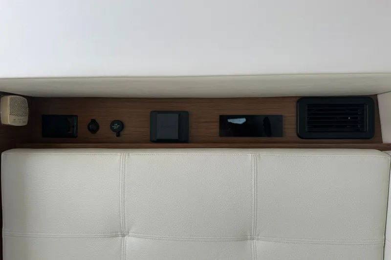 Slide: The Image of 2019 Cruisers Yachts 338 Outboard interior storage compartment with white cushioned seating. - 21