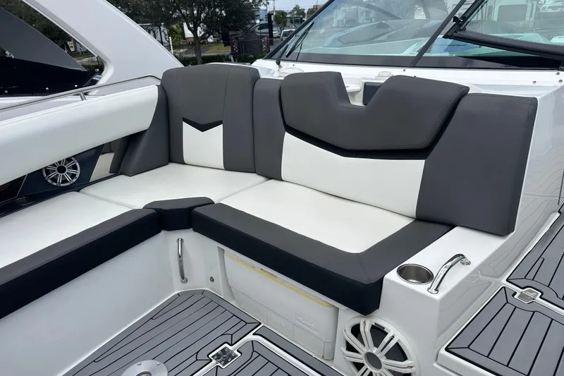 Slide: The Image of 2019 Cruisers Yachts 338 Outboard interior seating with gray and white upholstery. - 11