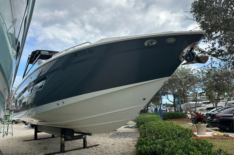 Slide: The Image of 2019 Cruisers Yachts 338 Outboard boat on display, side view with trees and sky background. - 2