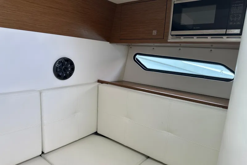 Slide: The Image of Interior of 2019 Cruisers Yachts 338 Outboard with white seating and a microwave. - 25