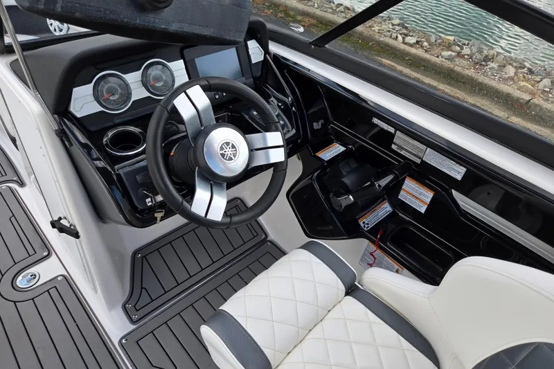 Slide: The Image of 2018 Yamaha Boats 212X cockpit with steering wheel, gauges, and seating. - 12