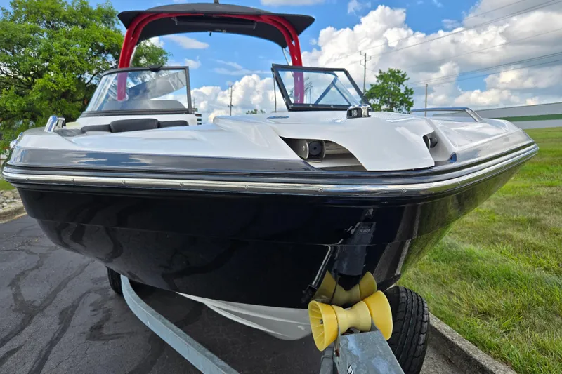 Slide: The Image of 2018 Yamaha Boats 212X on trailer, sleek design, blue sky background. - 6