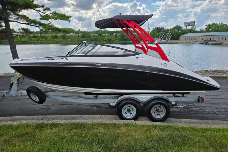 Slide: The Image of 2018 Yamaha Boats 212X on trailer by a scenic lakeside. - 9