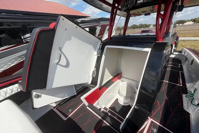 Slide: The Image of 2018 Statement 380 Open boat interior with open storage compartment, featuring sleek black and red design. - 18