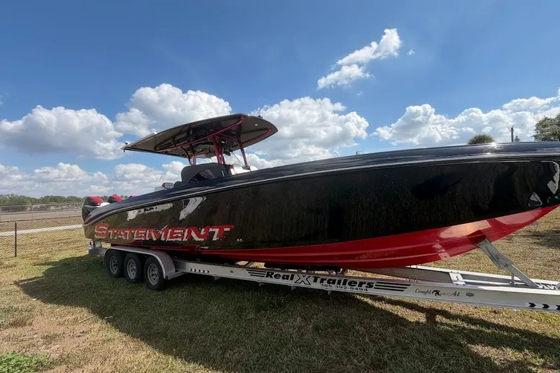 Slide: The Image of 2018 Statement 380 Open boat on trailer under blue sky. - 2