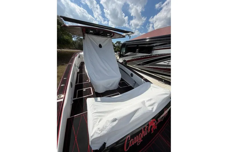 Slide: The Image of 2018 Statement 380 Open boat with covered seating, under a partly cloudy sky. - 27