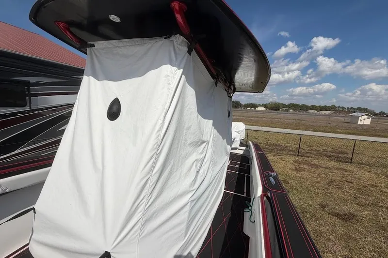 Slide: The Image of 2018 Statement 380 Open boat with white cover, parked outdoors under blue sky. - 31