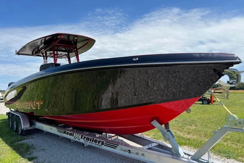 Slide: The Image of 2018 Statement 380 Open boat on trailer, black and red design, parked on grass. - 4