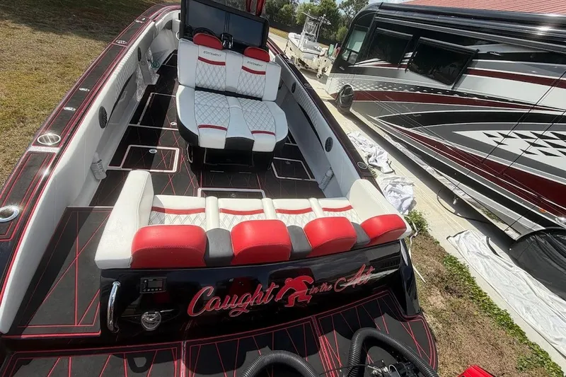 Slide: The Image of 2018 Statement 380 Open boat with red and white seating, parked beside an RV. - 8