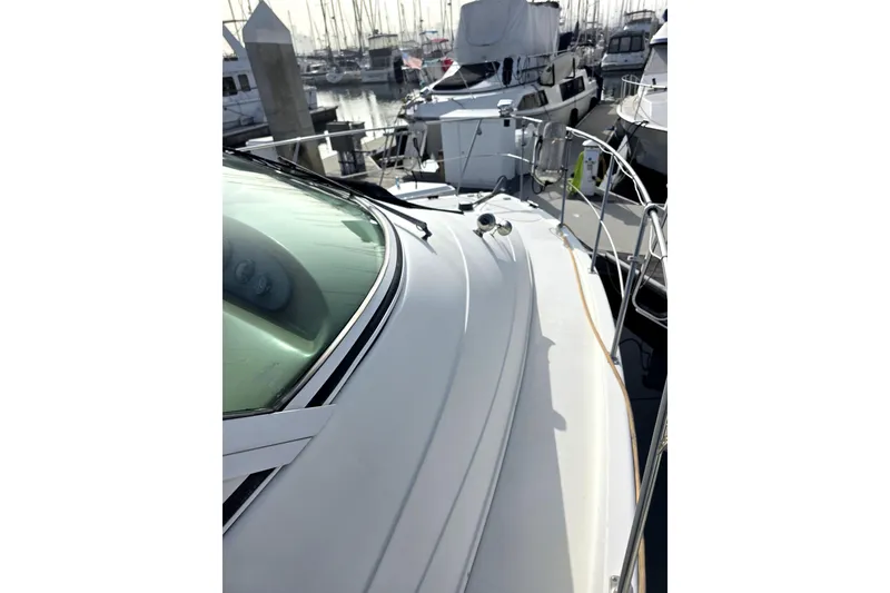 Slide: The Image of 2001 Carver 350 Mariner yacht docked in a marina, showcasing sleek design and spacious deck. - 10