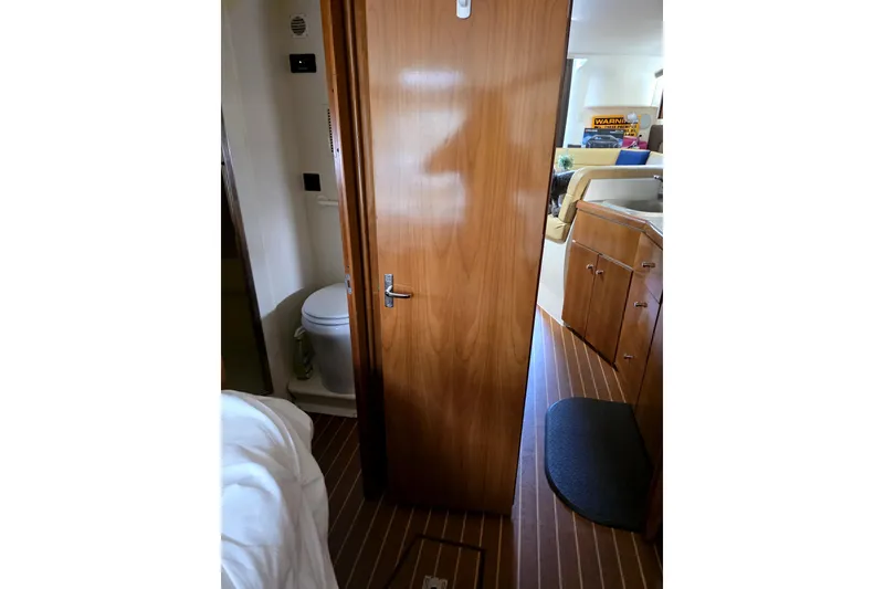 Slide: The Image of Interior of 2001 Carver 350 Mariner yacht, featuring wooden cabinetry and compact bathroom. - 12