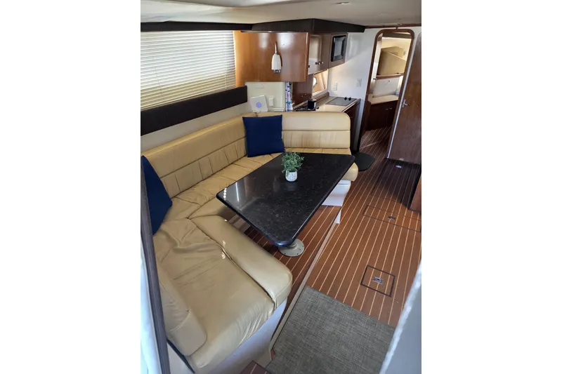 Slide: The Image of 2001 Carver 350 Mariner interior with beige seating, black table, and wooden flooring. - 4