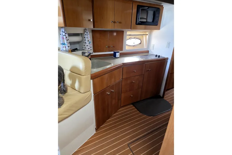 Slide: The Image of 2001 Carver 350 Mariner interior with wooden cabinets, sink, and microwave. - 7