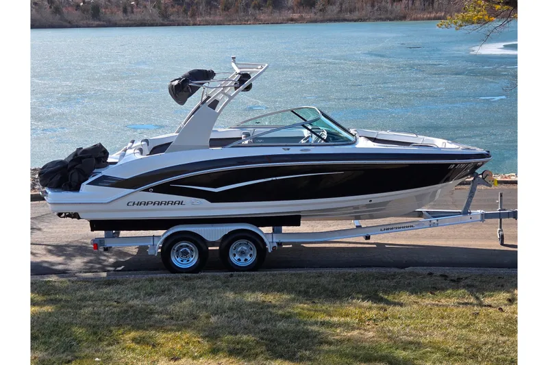 Slide: The Image of 2018 Chaparral Vortex 223 VR boat on trailer by a lake. - 0