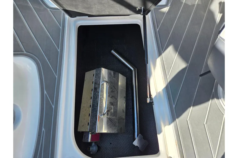 Slide: The Image of Storage compartment in 2018 Chaparral Vortex 223 VR boat with metal tools inside. - 12