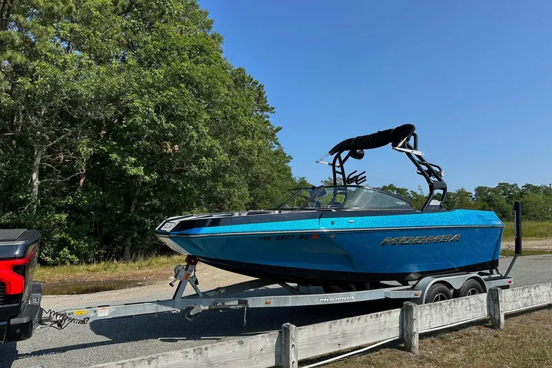 Slide: The Image of 2019 Moomba Helix boat on trailer, parked near lush green trees. - 3