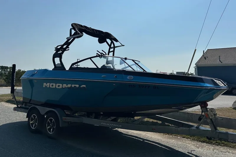 Slide: The Image of 2019 Moomba Helix boat on trailer, blue exterior, parked outdoors. - 5