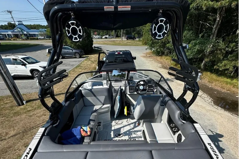 Slide: The Image of 2019 Moomba Helix boat interior with seating and audio system, parked outdoors. - 7