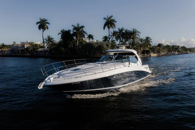 Slide: The Image of 2008 Sea Ray 440 Sundancer yacht cruising on a scenic waterway with palm trees. - 2