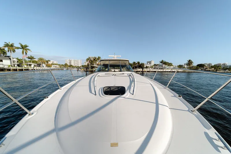 Slide: The Image of 2008 Sea Ray 440 Sundancer yacht cruising on a sunny day, with waterfront view. - 12