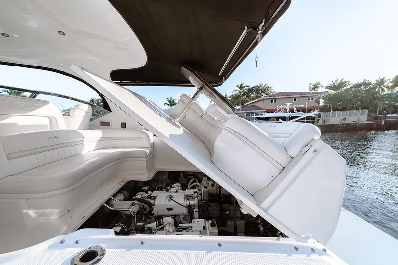 Slide: The Image of 2008 Sea Ray 440 Sundancer yacht with open engine compartment, docked by waterfront homes. - 27